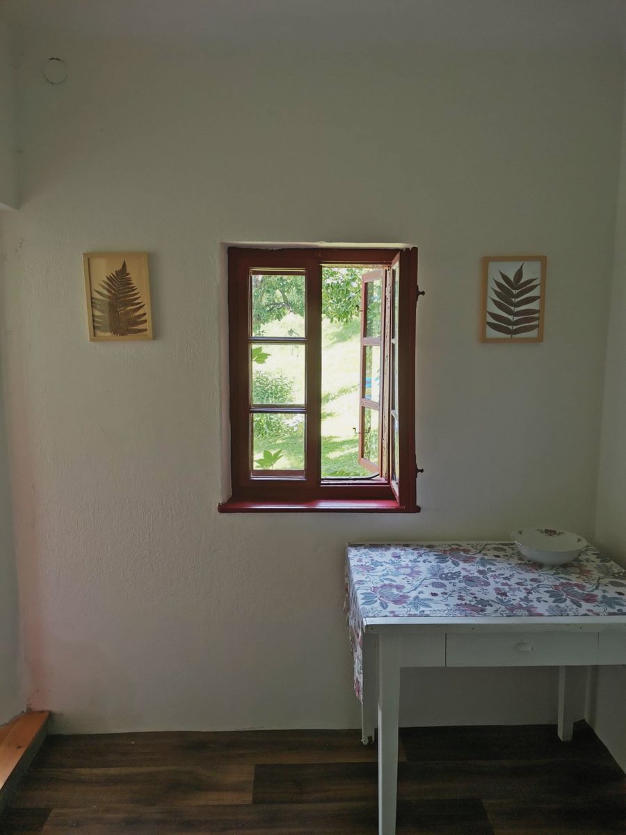 Malé okno s červeným rámem a stolek